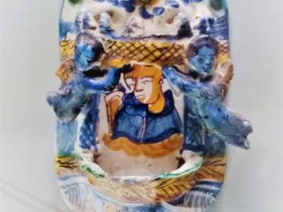 ...sormontato da due putti in rilevo che reggono un corona